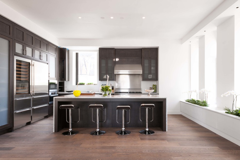 Moderne Küche in L-Form mit Schrankfronten im Shaker-Stil, dunklen Holzschränken, Küchengeräten aus Edelstahl, dunklem Holzboden und Kücheninsel in New York