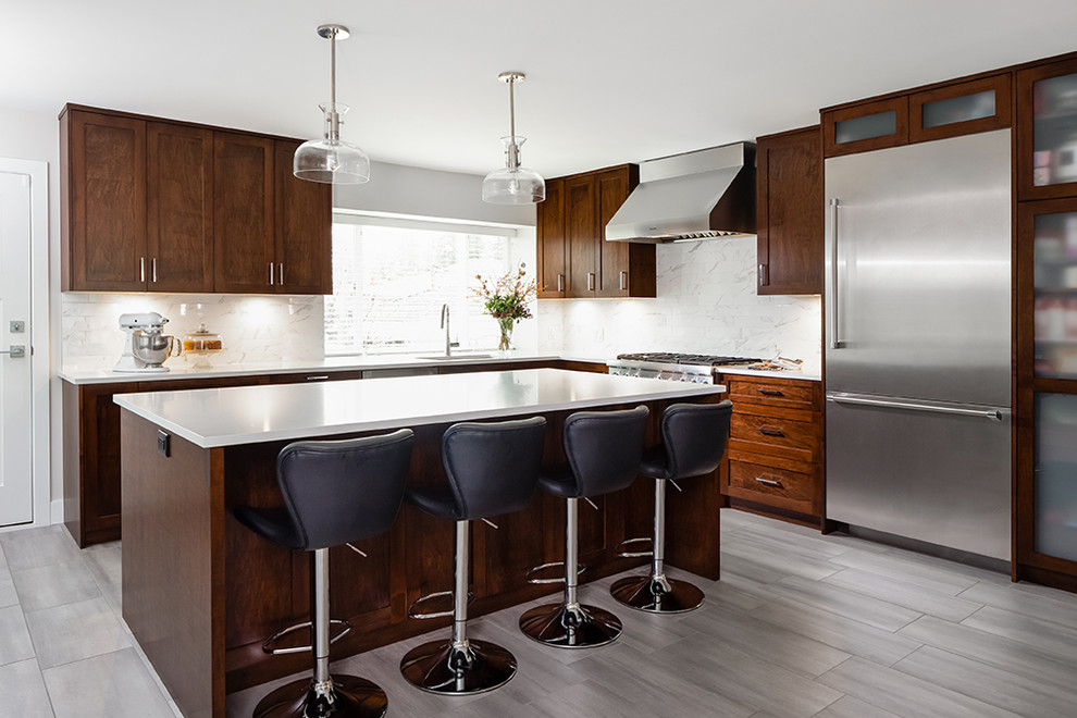 Idee per una cucina moderna di medie dimensioni con lavello sottopiano, ante in stile shaker, ante in legno bruno, paraspruzzi beige, elettrodomestici in acciaio inossidabile, pavimento grigio e top bianco