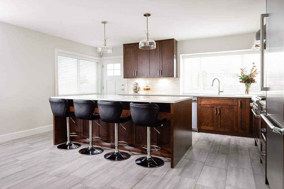 Esempio di una cucina minimalista di medie dimensioni con lavello sottopiano, ante in stile shaker, ante in legno bruno, paraspruzzi beige, elettrodomestici in acciaio inossidabile, pavimento grigio e top bianco