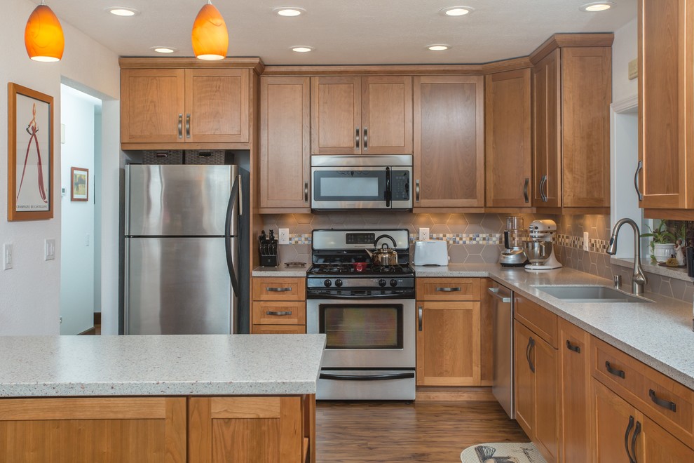 Mid-sized transitional l-shaped open concept kitchen photo in Other with an undermount sink, shaker cabinets, medium tone wood cabinets, quartz countertops, gray backsplash, porcelain backsplash, stainless steel appliances and an island