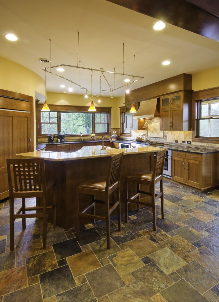 Exempel på ett stort amerikanskt flerfärgad flerfärgat u-kök, med en undermonterad diskho, skåp i shakerstil, skåp i mellenmörkt trä, granitbänkskiva, gult stänkskydd, stänkskydd i travertin, rostfria vitvaror, skiffergolv, en köksö och flerfärgat golv