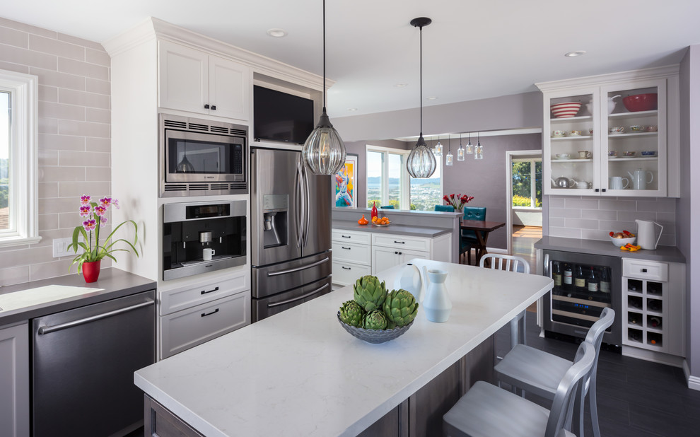 Large classic grey and white u-shaped kitchen/diner in San Francisco with shaker cabinets, white cabinets, grey splashback, stainless steel appliances, an island, a single-bowl sink, composite countertops, metro tiled splashback and porcelain flooring.