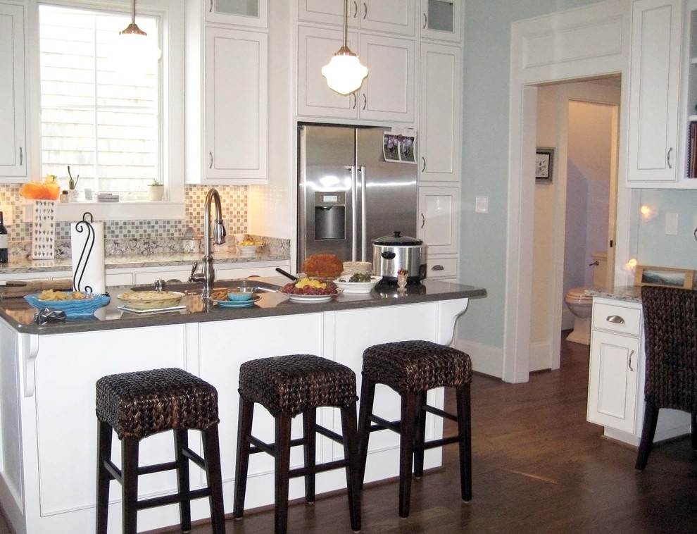 Klassisk inredning av ett mellanstort linjärt kök och matrum, med luckor med infälld panel, vita skåp, flerfärgad stänkskydd, stänkskydd i mosaik, rostfria vitvaror, mörkt trägolv och en köksö