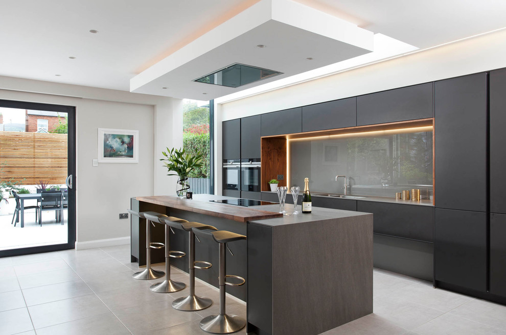 This is an example of a large modern single-wall open plan kitchen in Belfast with glass-front cabinets and an island.