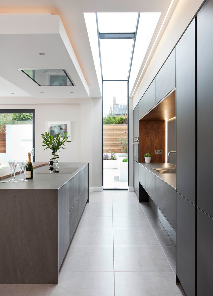 Imagen de cocina lineal minimalista grande abierta con armarios tipo vitrina y una isla