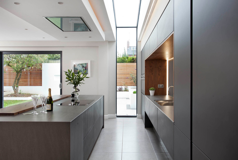 Imagen de cocina lineal minimalista grande abierta con armarios tipo vitrina y una isla