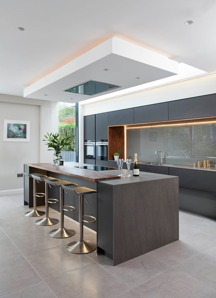 Large modern single-wall open plan kitchen in Belfast with glass-front cabinets and an island.
