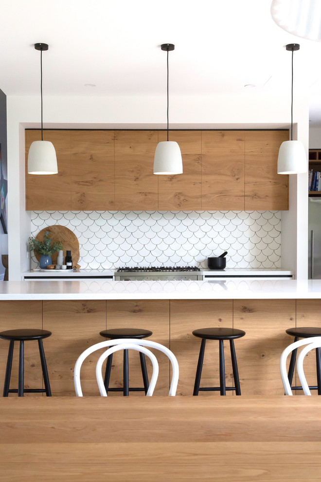 Inspiration for a contemporary galley kitchen remodel in Melbourne with flat-panel cabinets, light wood cabinets, white backsplash, stainless steel appliances and an island