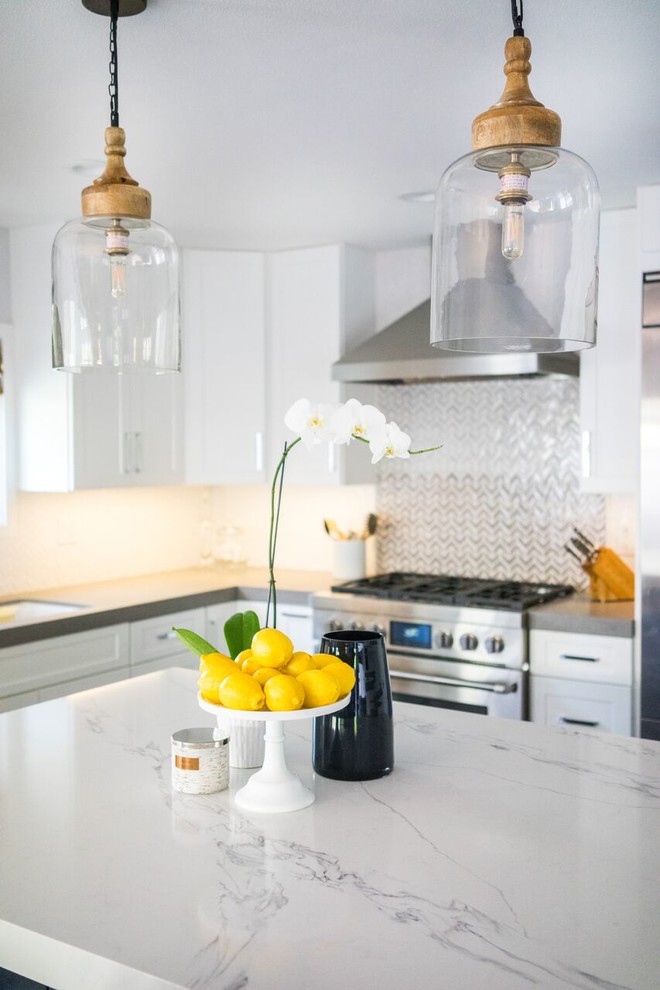 Immagine di una cucina costiera con ante in stile shaker, ante bianche, paraspruzzi bianco, elettrodomestici in acciaio inossidabile, parquet scuro e pavimento marrone