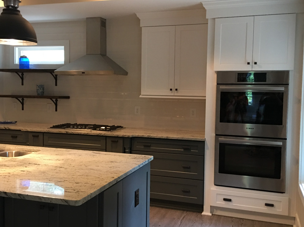 This is an example of a large rural single-wall open plan kitchen in Atlanta with a submerged sink, shaker cabinets, grey cabinets, granite worktops, white splashback, stainless steel appliances, light hardwood flooring, an island, brown floors and beige worktops.