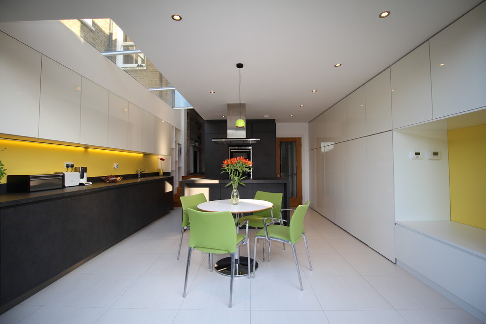 Inspiration for a contemporary kitchen in London with yellow splashback.