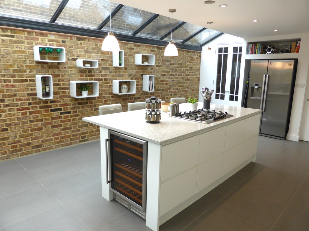 Große Moderne Wohnküche mit flächenbündigen Schrankfronten, weißen Schränken, Quarzit-Arbeitsplatte, Küchenrückwand in Weiß und Kücheninsel in London