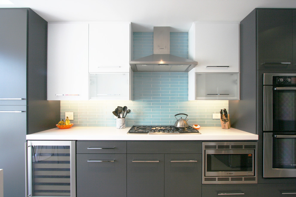 Foto di una cucina minimal di medie dimensioni con ante lisce, ante grigie, top in quarzo composito, paraspruzzi blu, paraspruzzi con piastrelle di vetro, elettrodomestici in acciaio inossidabile e pavimento in gres porcellanato