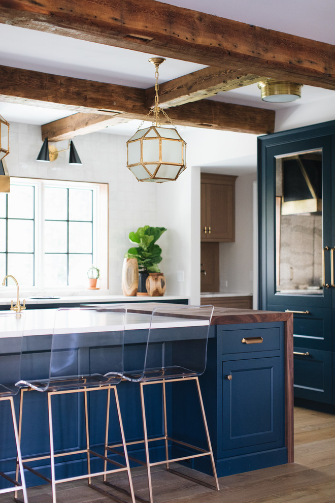 Eat-in kitchen - mid-sized transitional galley medium tone wood floor and brown floor eat-in kitchen idea in Grand Rapids with a farmhouse sink, shaker cabinets, blue cabinets, quartz countertops and an island