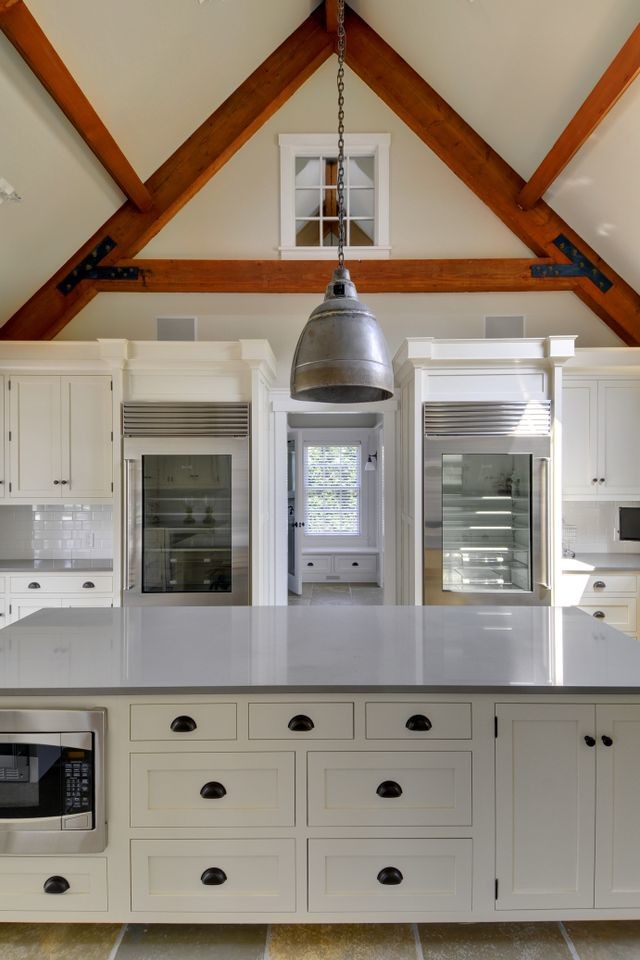 Design ideas for a large traditional u-shaped kitchen in New York with a belfast sink, shaker cabinets, white cabinets, white splashback, metro tiled splashback, stainless steel appliances and an island.