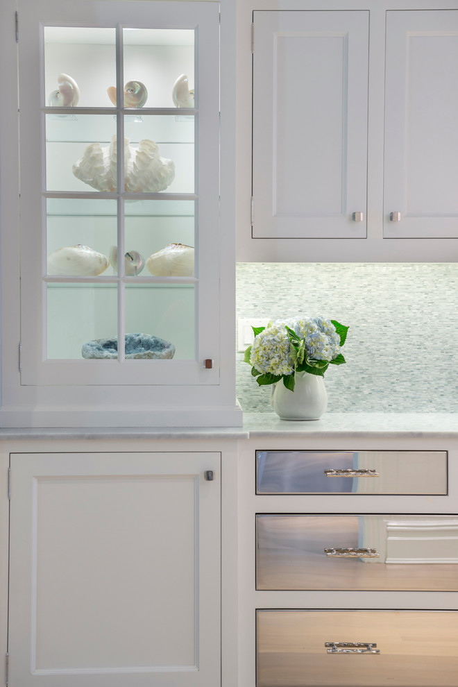 Foto de cocina costera pequeña cerrada con armarios estilo shaker, puertas de armario blancas, electrodomésticos de acero inoxidable y suelo de madera clara