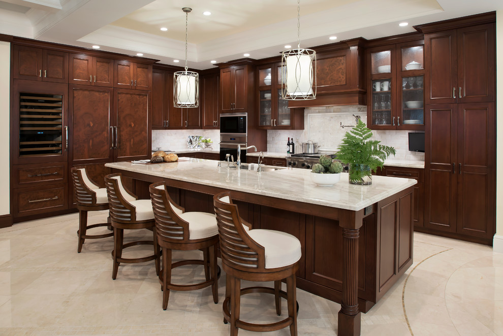 Example of a mid-sized classic l-shaped marble floor kitchen design in Miami with dark wood cabinets, quartzite countertops, white backsplash, stone tile backsplash, paneled appliances, an island, an undermount sink and beaded inset cabinets