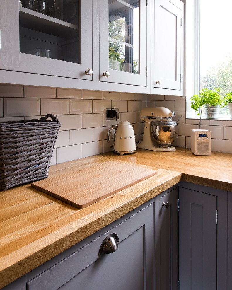 Small classic kitchen/diner in London with light wood cabinets, wood worktops and an island.