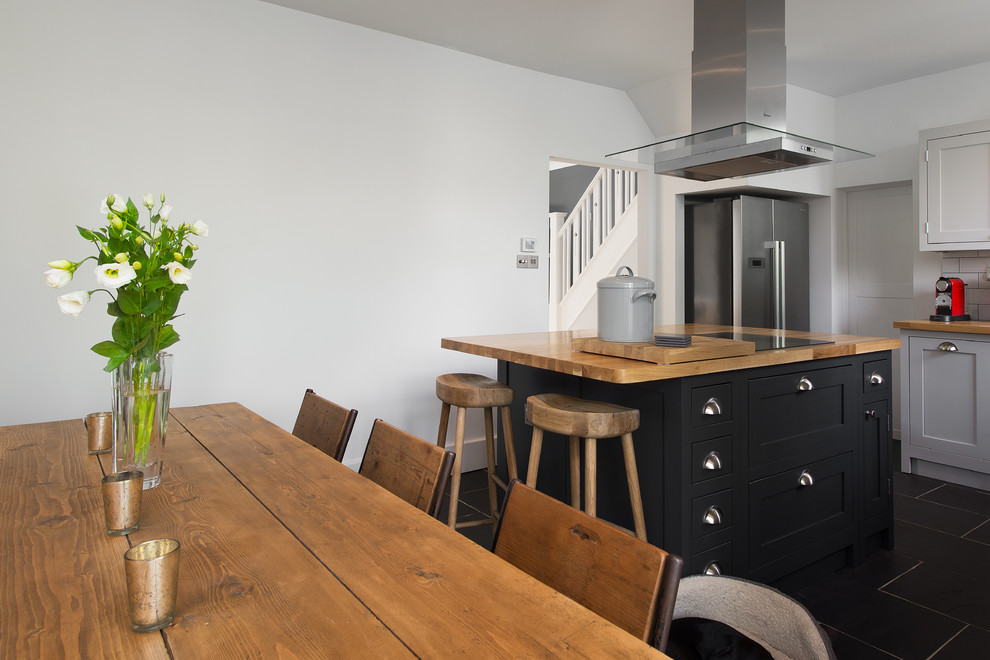 Diseño de cocina comedor clásica renovada pequeña con puertas de armario de madera clara, encimera de madera y una isla