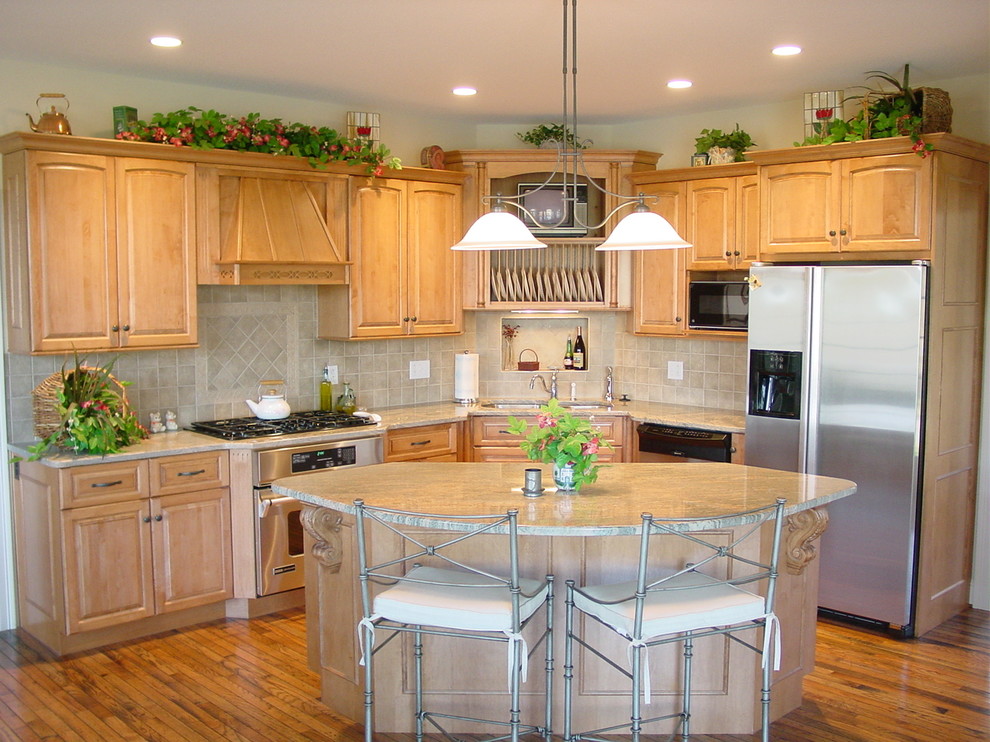 Bild på ett medelhavsstil kök, med en undermonterad diskho, luckor med upphöjd panel, skåp i mellenmörkt trä, granitbänkskiva, stänkskydd i keramik, rostfria vitvaror, mellanmörkt trägolv, en köksö och beige stänkskydd