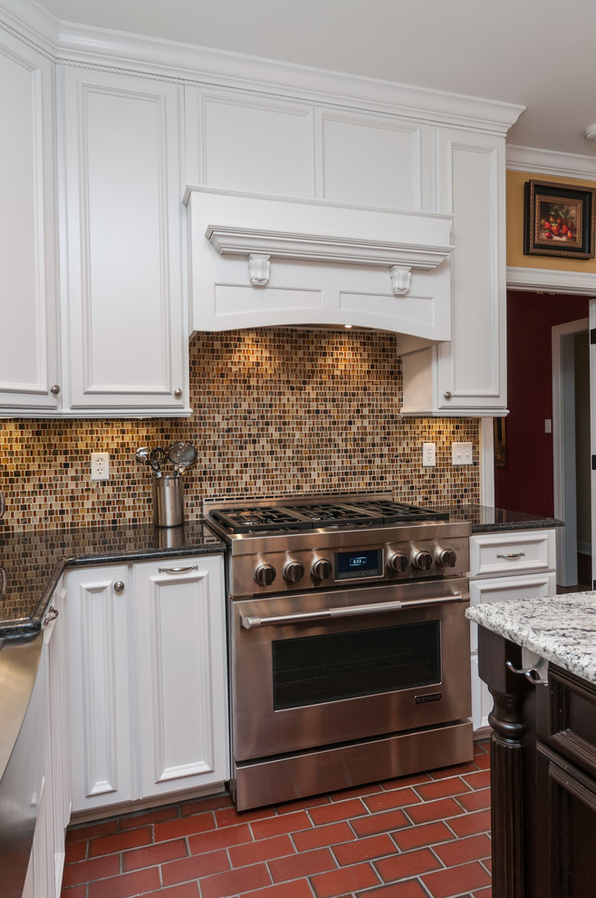 Example of a large classic u-shaped brick floor eat-in kitchen design in Other with a farmhouse sink, recessed-panel cabinets, white cabinets, quartz countertops, multicolored backsplash, mosaic tile backsplash, stainless steel appliances and an island