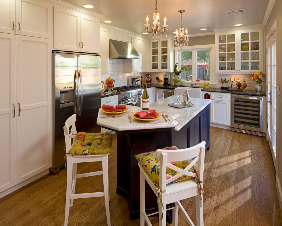 Klassische Küche in L-Form mit Glasfronten, Küchengeräten aus Edelstahl und Landhausspüle in Sacramento