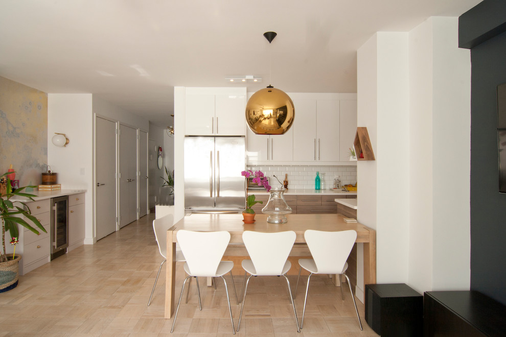 Small modern galley kitchen/diner in New York with a submerged sink, flat-panel cabinets, white cabinets, engineered stone countertops, white splashback, metro tiled splashback, stainless steel appliances, light hardwood flooring, no island and beige floors.