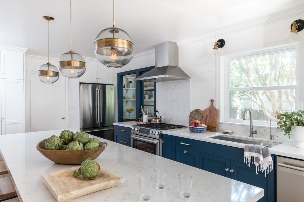 Large traditional kitchen/diner in Sacramento with a submerged sink, shaker cabinets, blue cabinets, quartz worktops, stone slab splashback, stainless steel appliances, medium hardwood flooring, an island and brown floors.