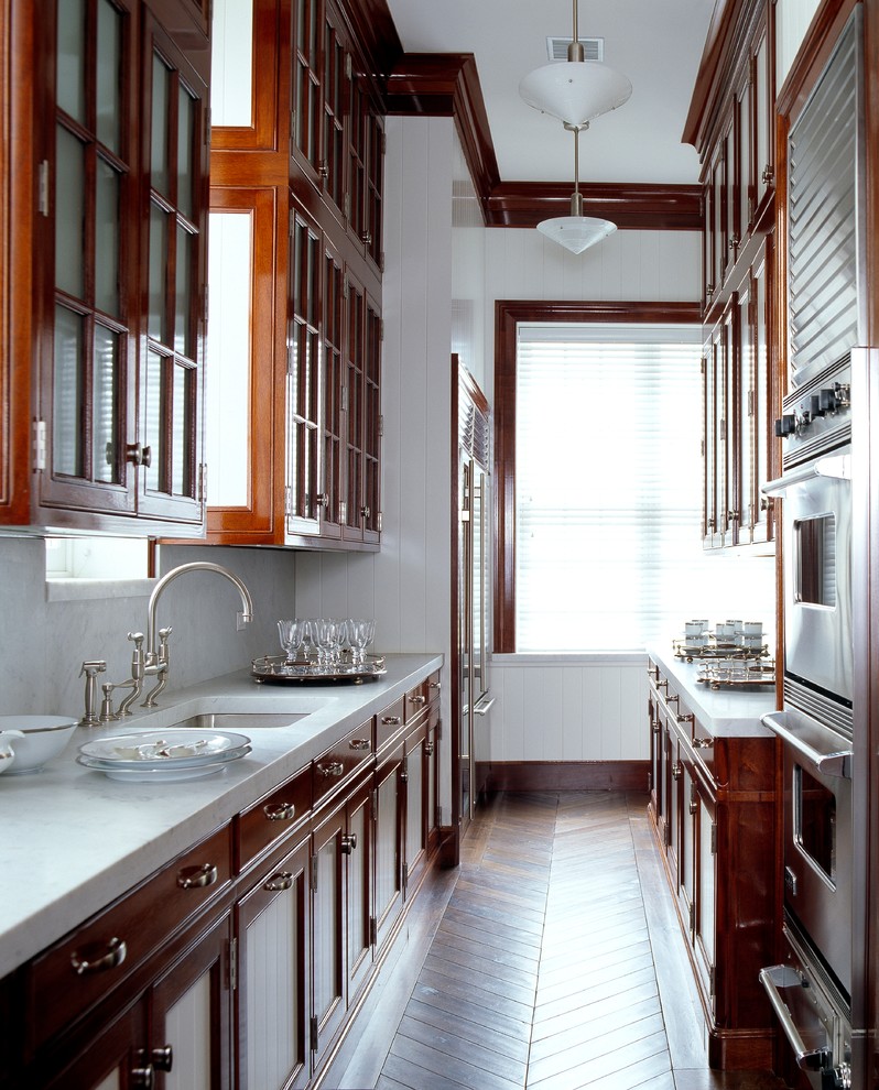 Ejemplo de cocina clásica renovada con fregadero bajoencimera, armarios con paneles empotrados, puertas de armario de madera oscura y suelo de madera en tonos medios