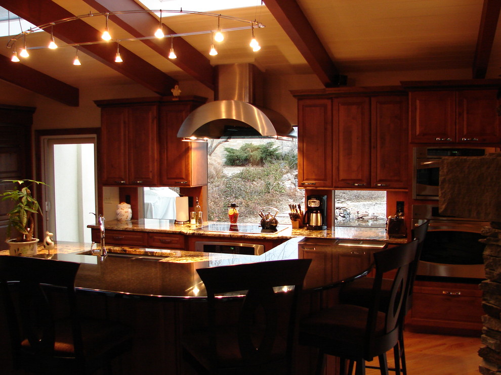 Esempio di una cucina classica con lavello sottopiano, ante con bugna sagomata, ante in legno scuro, top in granito e elettrodomestici in acciaio inossidabile