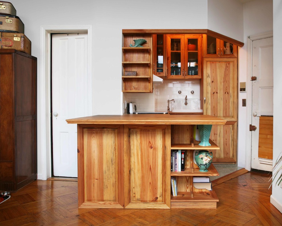 Exemple d'une cuisine chic avec un placard à porte vitrée et un plan de travail en bois.