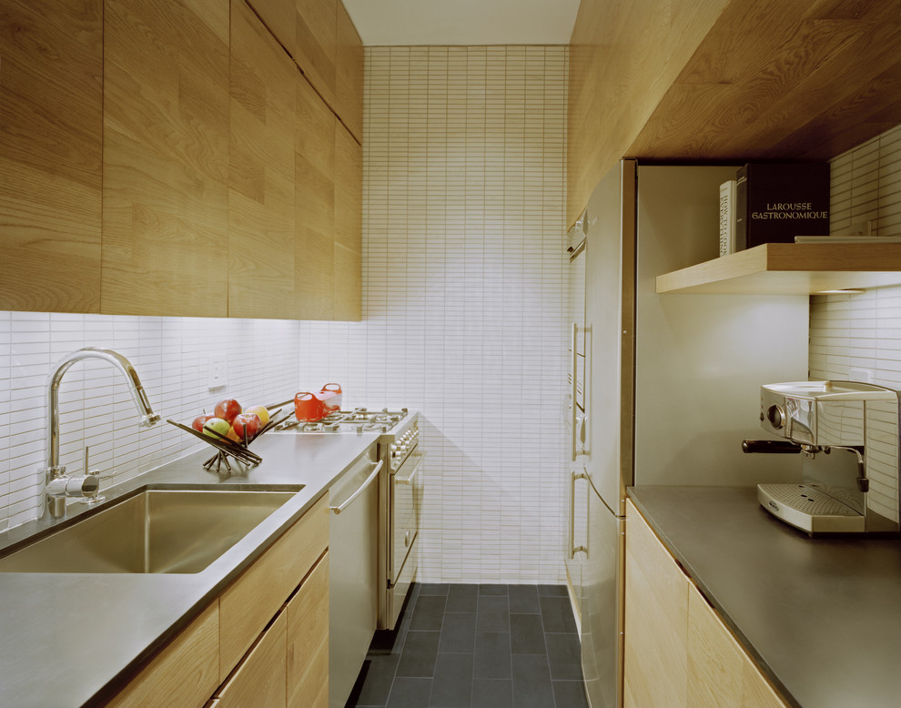 На фото: узкая кухня в современном стиле с техникой из нержавеющей стали