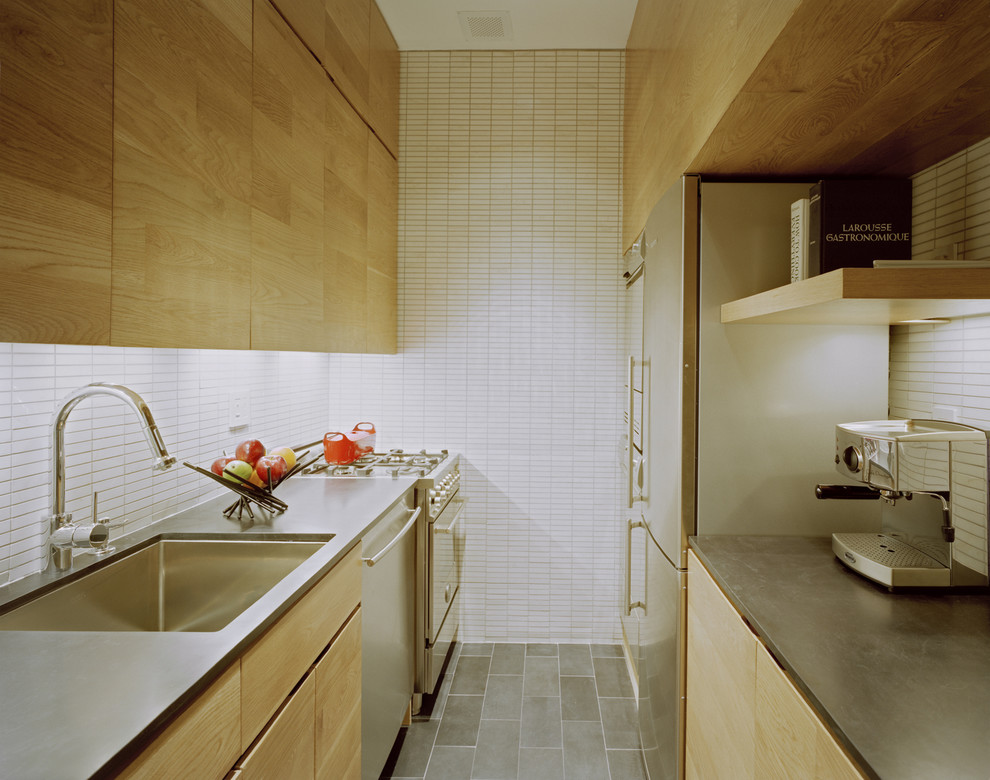 На фото: параллельная, отдельная кухня в стиле модернизм с техникой из нержавеющей стали