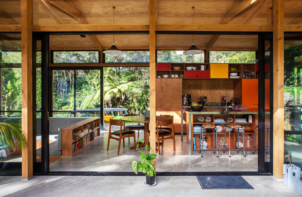 Стильный дизайн: прямая кухня-гостиная в современном стиле с столешницей из нержавеющей стали и бетонным полом - последний тренд