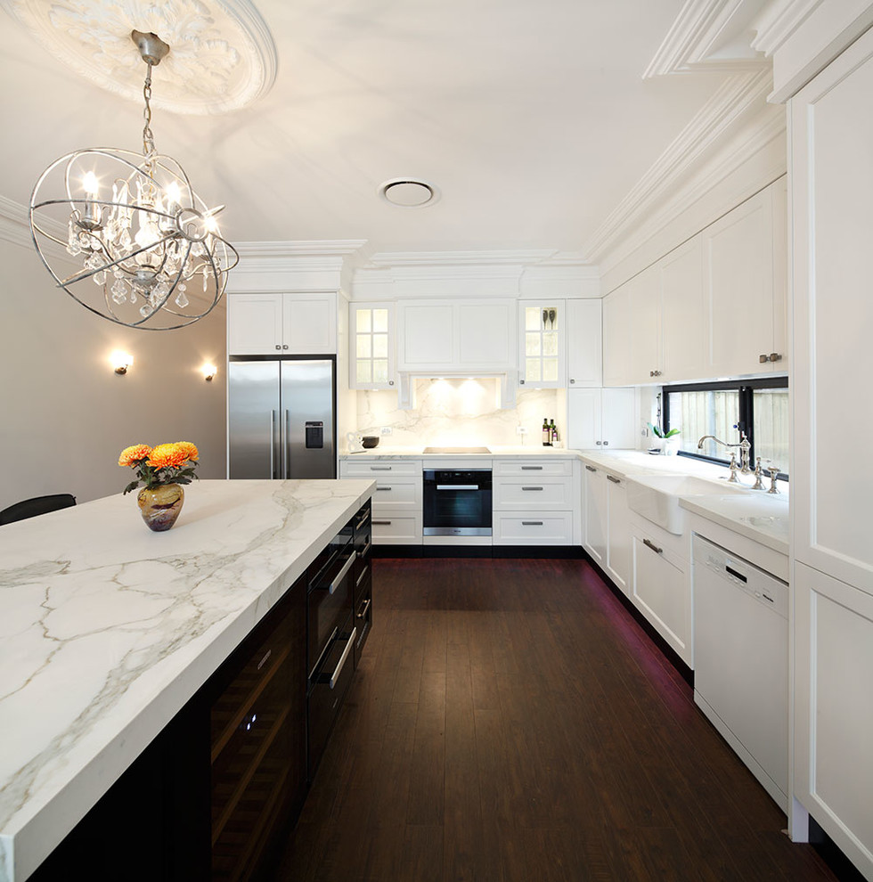 Mid-sized elegant l-shaped dark wood floor eat-in kitchen photo in Sydney with a farmhouse sink, recessed-panel cabinets, white cabinets, marble countertops, multicolored backsplash, stone slab backsplash, stainless steel appliances and an island