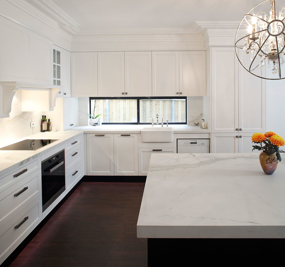 Inspiration for a mid-sized timeless l-shaped dark wood floor eat-in kitchen remodel in Sydney with a farmhouse sink, recessed-panel cabinets, white cabinets, marble countertops, multicolored backsplash, stone slab backsplash, stainless steel appliances and an island