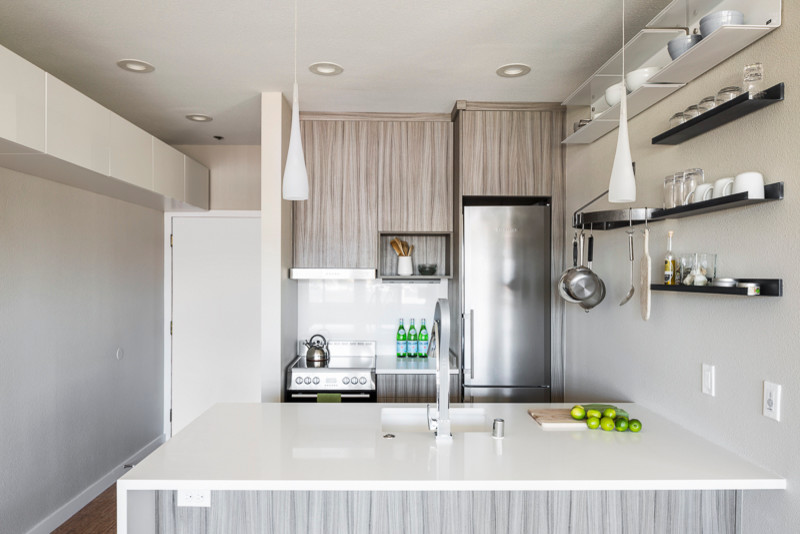 Zweizeilige, Kleine Moderne Wohnküche ohne Insel mit Unterbauwaschbecken, flächenbündigen Schrankfronten, braunen Schränken, Quarzit-Arbeitsplatte, Küchenrückwand in Weiß, Küchengeräten aus Edelstahl und Korkboden in Seattle