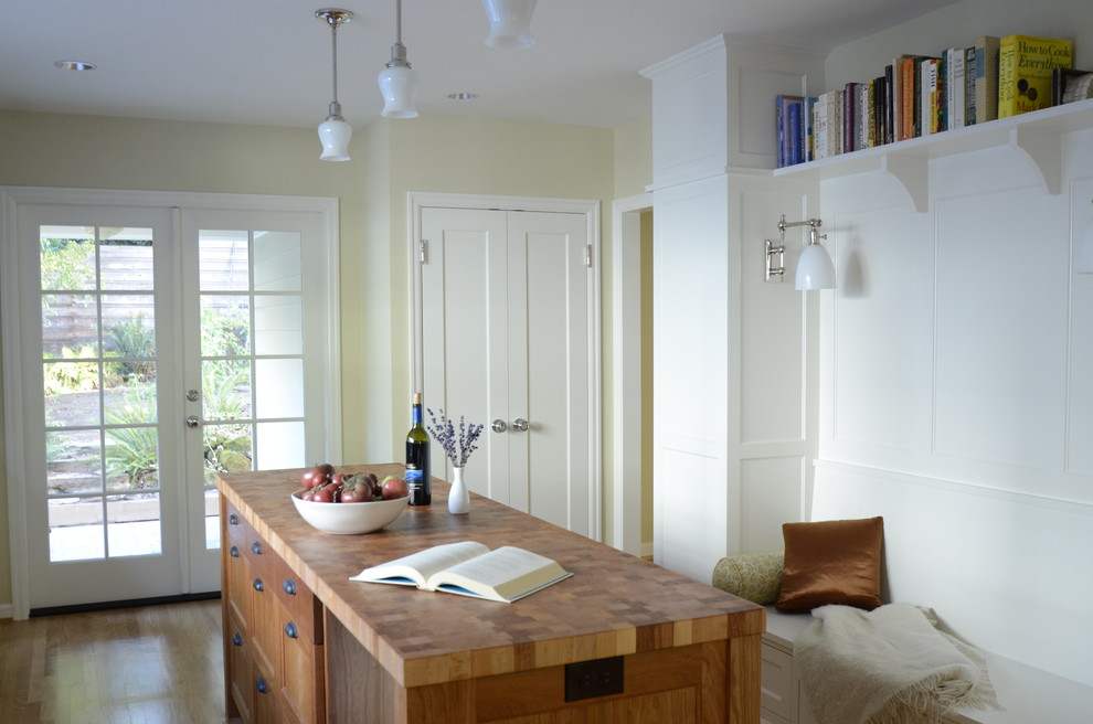 На фото: параллельная кухня в классическом стиле с обеденным столом и белыми фасадами с