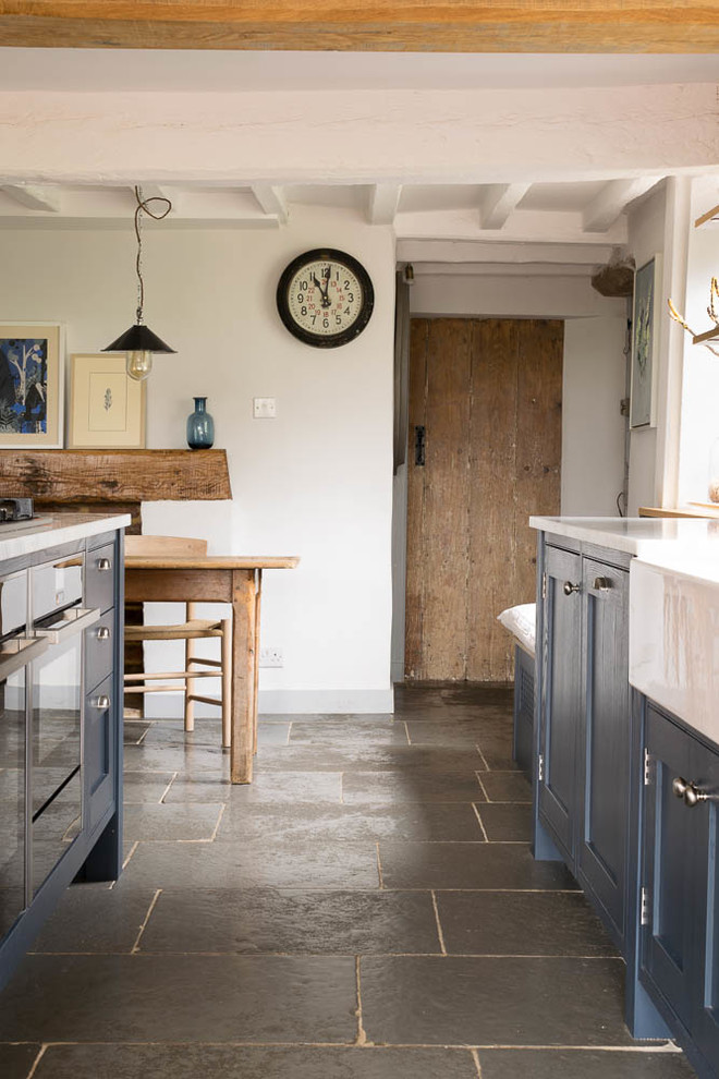 Idéer för ett mellanstort rustikt kök, med skåp i shakerstil, blå skåp, kalkstensgolv, en köksö och grått golv
