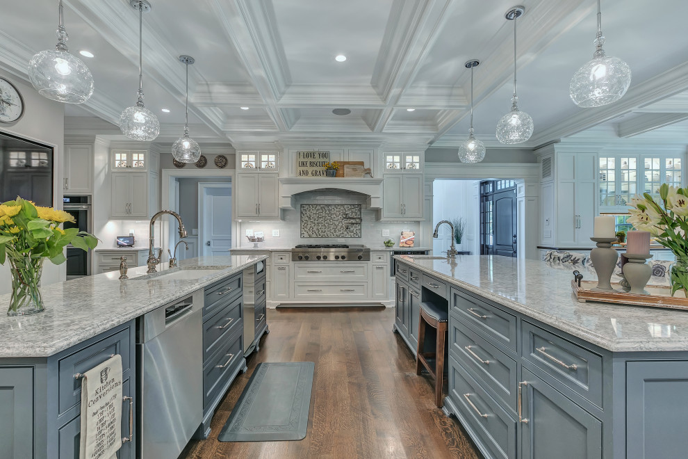 Inspiration for a large traditional u-shaped kitchen/diner in New York with a single-bowl sink, beaded cabinets, blue cabinets, engineered stone countertops, white splashback, glass tiled splashback, stainless steel appliances, dark hardwood flooring, multiple islands, brown floors and beige worktops.
