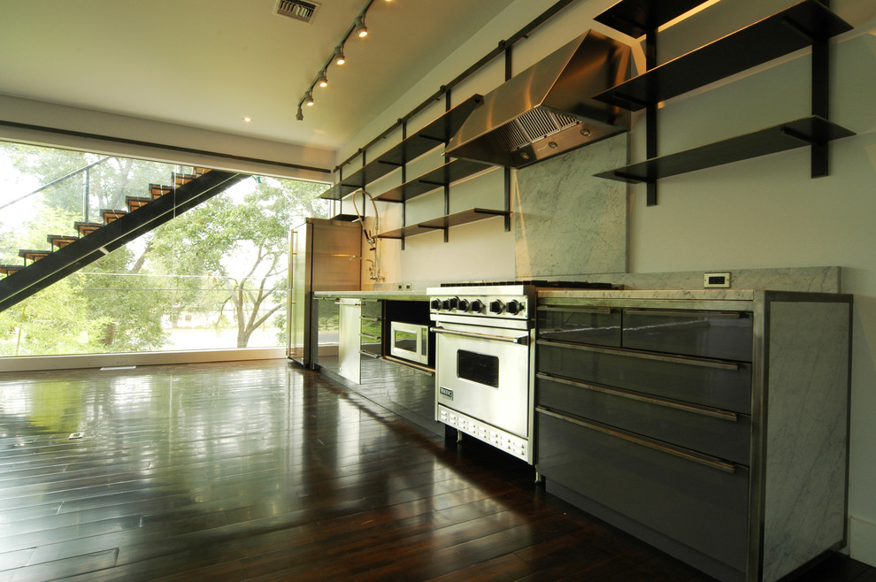 Example of a large minimalist galley dark wood floor eat-in kitchen design in Austin with a double-bowl sink, open cabinets, black cabinets, solid surface countertops, white backsplash, stainless steel appliances and an island
