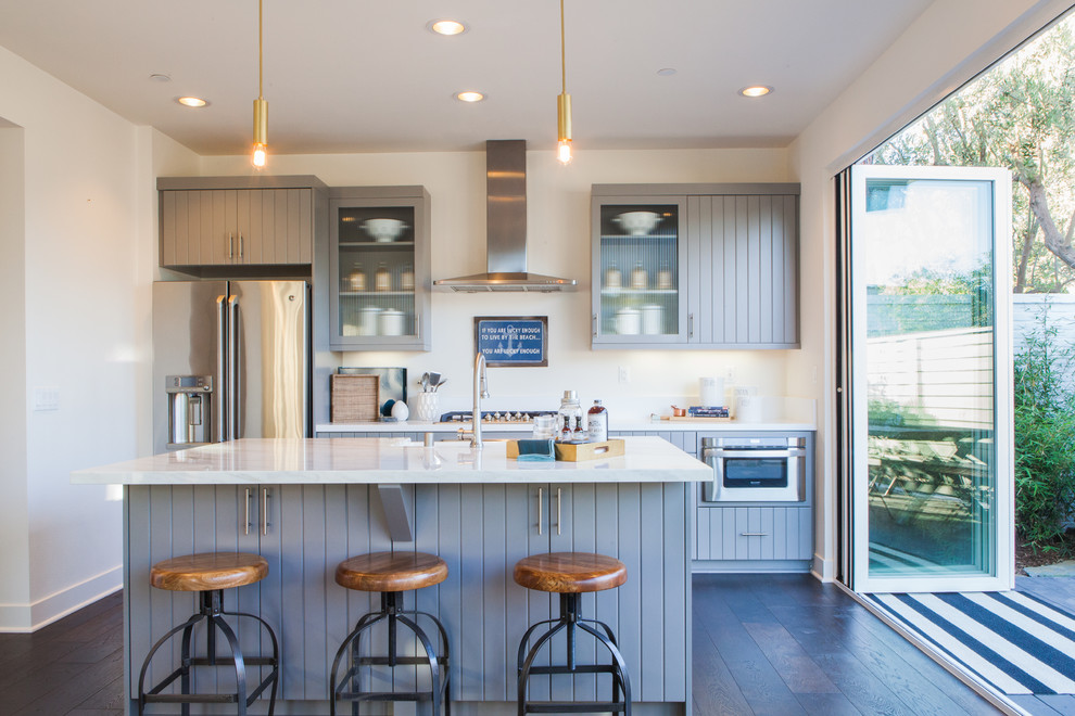 Zweizeilige Landhausstil Küche mit grauen Schränken, Küchengeräten aus Edelstahl, dunklem Holzboden und Kücheninsel in Orange County
