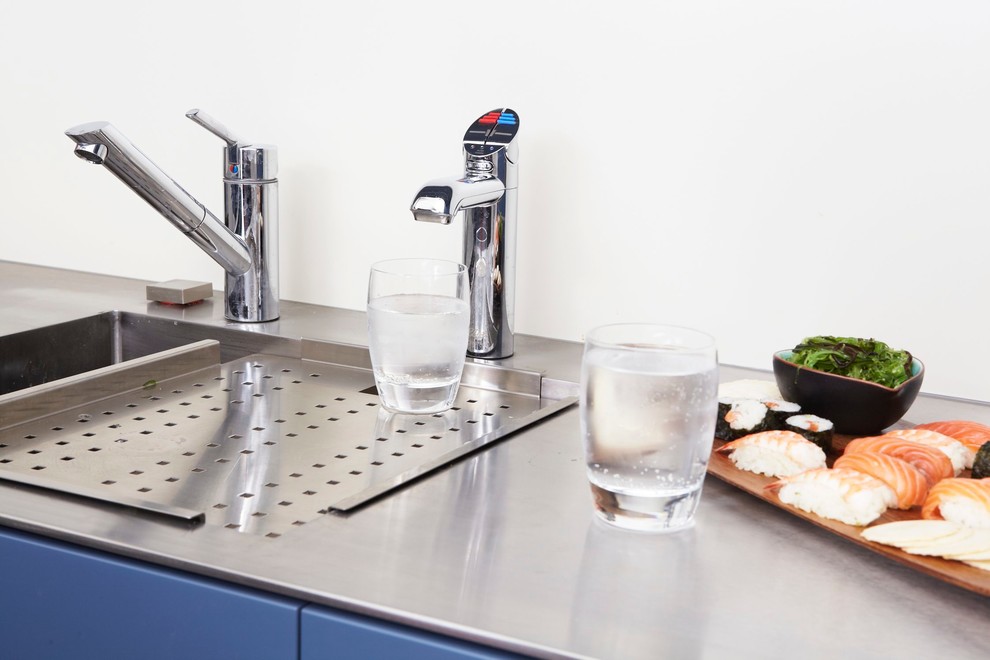 Eat-in kitchen - small contemporary u-shaped concrete floor and gray floor eat-in kitchen idea in Sydney with an integrated sink, flat-panel cabinets, blue cabinets, stainless steel countertops, glass sheet backsplash, stainless steel appliances, gray backsplash and a peninsula