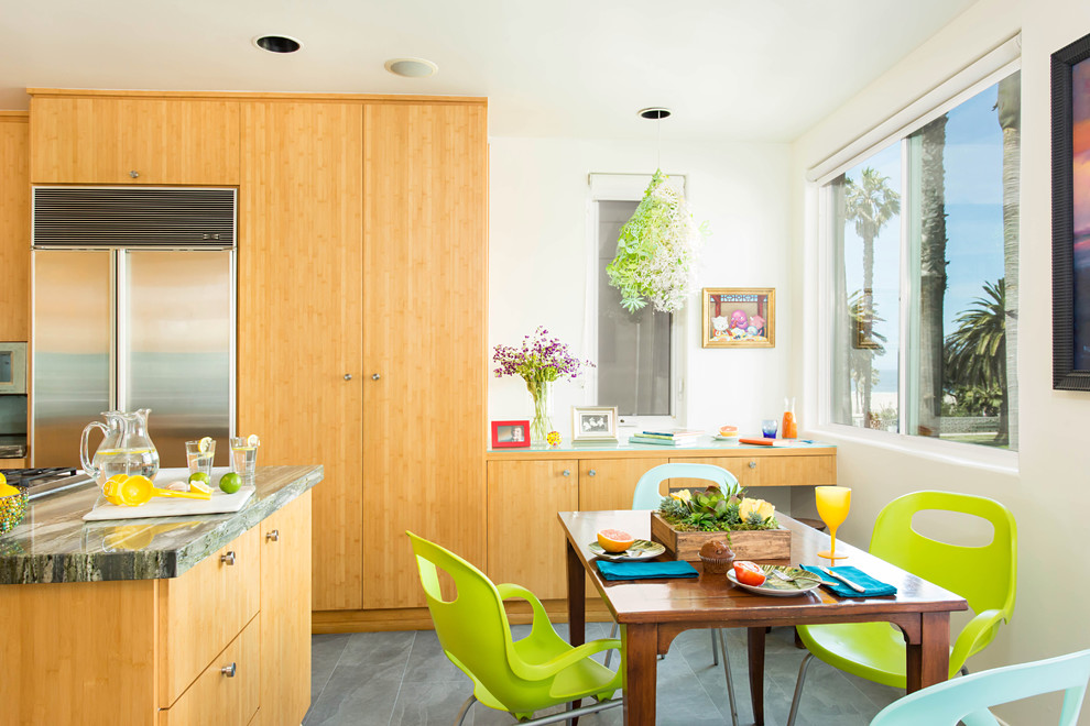 Eat-in kitchen - mid-sized coastal u-shaped porcelain tile and gray floor eat-in kitchen idea in Los Angeles with a double-bowl sink, flat-panel cabinets, light wood cabinets, granite countertops, blue backsplash, glass sheet backsplash, stainless steel appliances and an island
