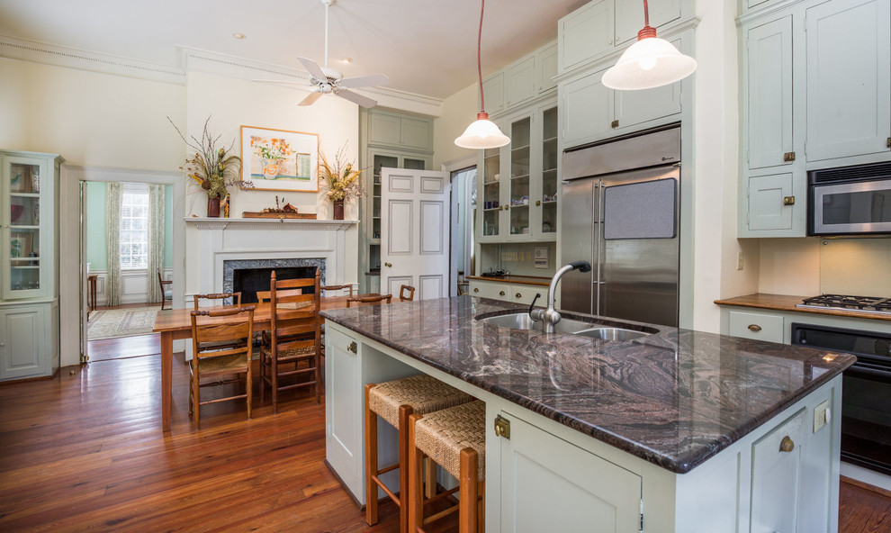 Inspiration for a traditional kitchen in Charleston with a double-bowl sink, blue cabinets, granite worktops, stainless steel appliances, medium hardwood flooring and an island.