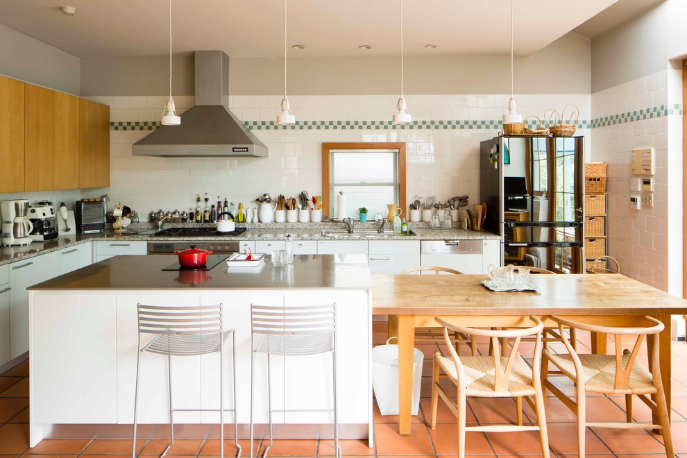 Стильный дизайн: угловая кухня в современном стиле с врезной мойкой, плоскими фасадами, белыми фасадами, белым фартуком, фартуком из керамической плитки, островом и коричневым полом - последний тренд