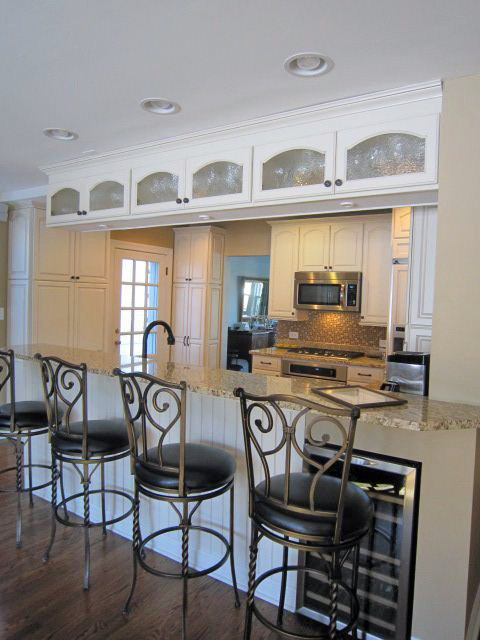 Пример оригинального дизайна: кухня в классическом стиле с обеденным столом, фасадами с декоративным кантом, белыми фасадами, гранитной столешницей, фартуком из плитки мозаики, темным паркетным полом и полуостровом