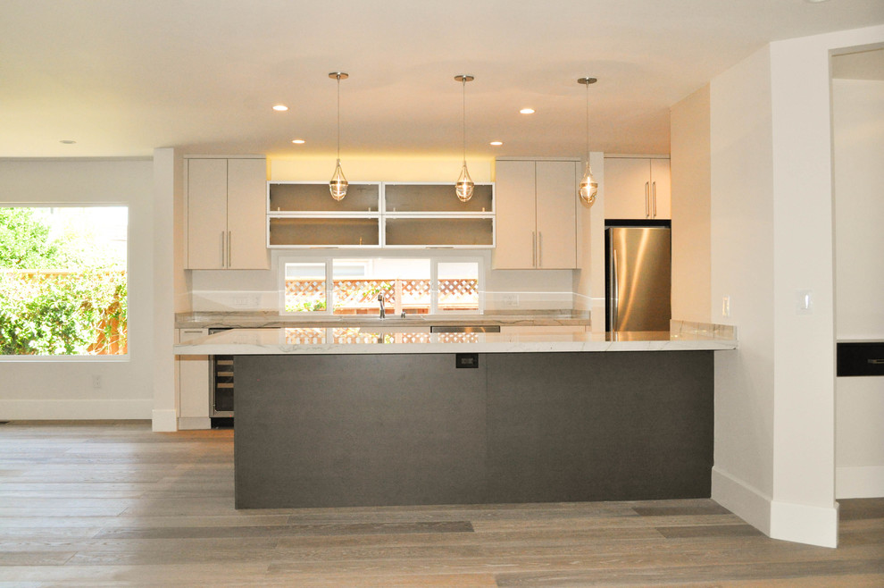 Photo of a contemporary u-shaped kitchen/diner in San Francisco with a submerged sink, flat-panel cabinets, white cabinets, granite worktops and stainless steel appliances.
