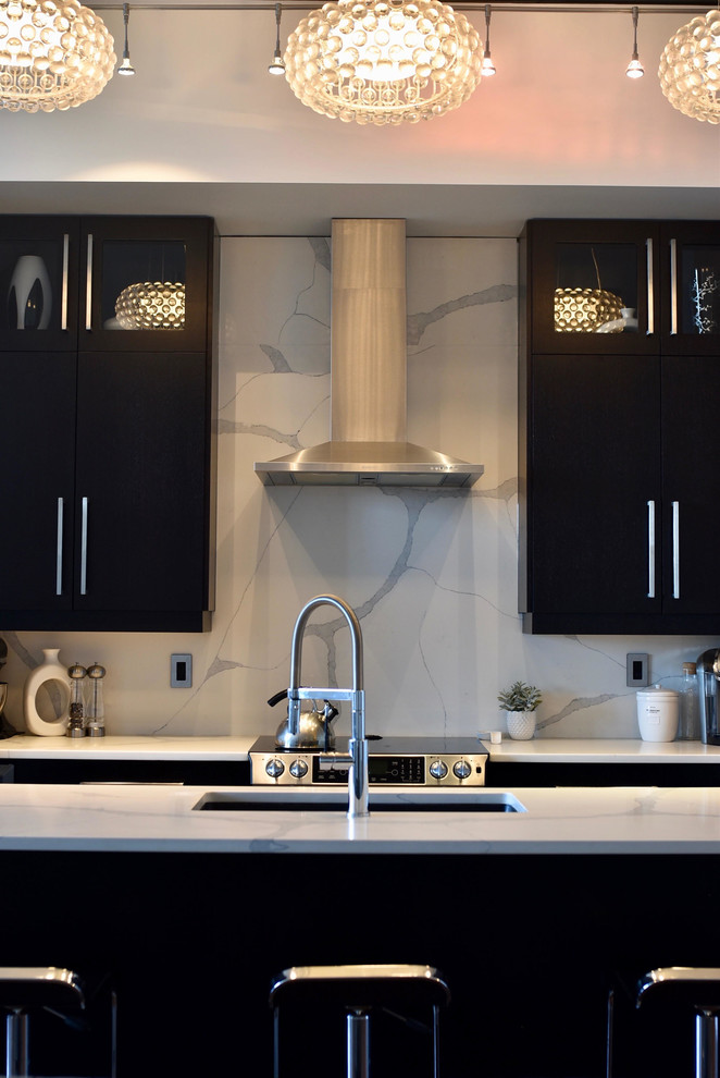 Exempel på ett mellanstort modernt linjärt kök och matrum, med granitbänkskiva, en undermonterad diskho, släta luckor, svarta skåp, vitt stänkskydd, stänkskydd i sten, rostfria vitvaror, en köksö och brunt golv