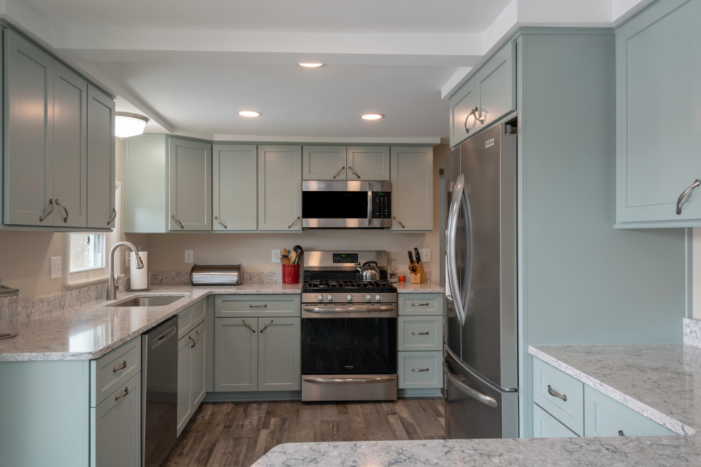 Exempel på ett avskilt, litet klassiskt grå grått l-kök, med en undermonterad diskho, skåp i shakerstil, gröna skåp, bänkskiva i kvarts, rostfria vitvaror, vinylgolv, en halv köksö och brunt golv